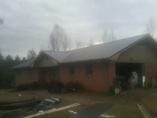 Gray metal roof on a stucco house with an attached garage in Valentines