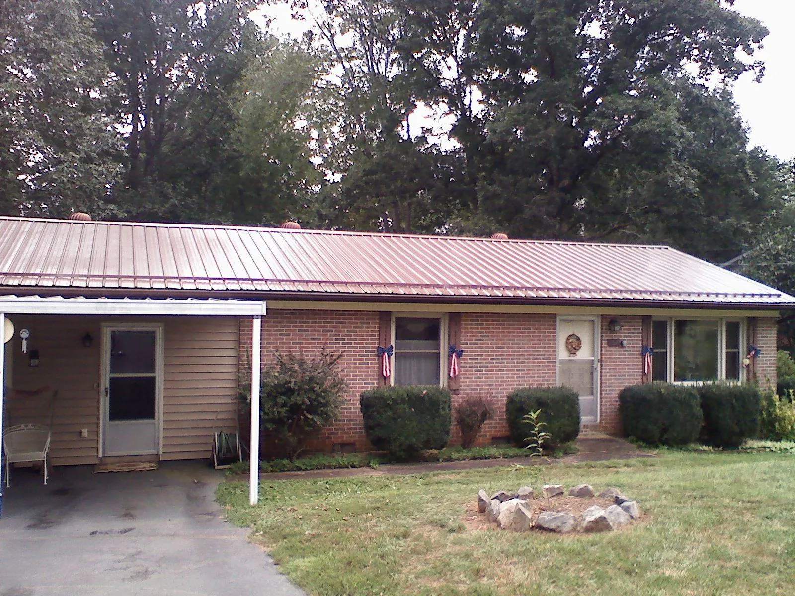 Bronze metal roof and carport on a brick ranch home — Roof Repair work by our crew in Valentines